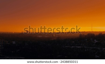 Wide view of brilliant orange skyline looking out towards East London with the sunset lighting up the clouds Royalty-Free Stock Photo #2438850311