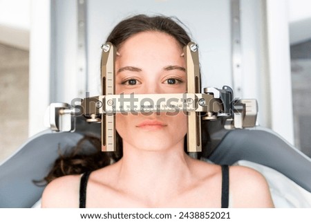 The patient lies in front of the device for the treatment of cancer with a gamma knife. She has a metal clip cap on his head. Gamma Knife stereotactic radiosurgery. Royalty-Free Stock Photo #2438852021