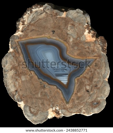 A thunderegg agate geode from the location known as Mine Shaft, New Mexico - a nice grey banded agate with hints of orange surrounded by a marbled matrix. This is a specimen that has been cut in half. Royalty-Free Stock Photo #2438852771