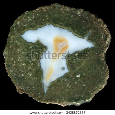 A thunderegg agate geode from the location known as Desolation Canyon, Oregon. A bright white agate with yellow areas surrounded by a deep green matrix.This is a specimen that has been cut in half and Royalty-Free Stock Photo #2438852999