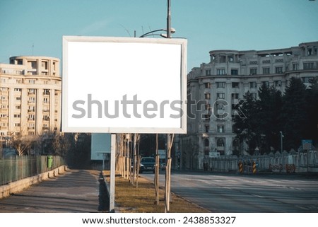 An empty white billboard in the city center