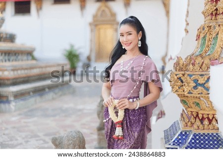 Portrait of a beautiful thai woman wearing a thai dress,Thai girl in retro Thai dress,Beautiful Thai girl in traditional dress costume
