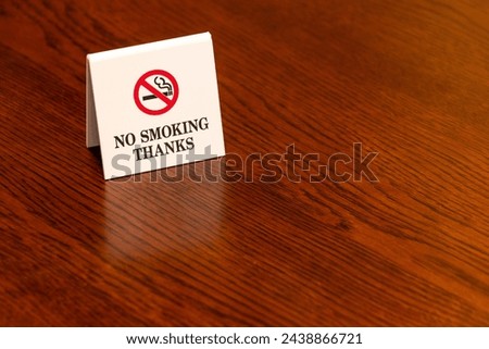 A white sign indicating non-smoking seat on a wooden table