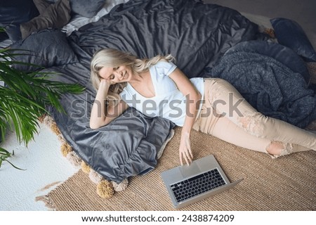 Happy beautiful blonde woman working, making video call, watching movie on a laptop in cozy home bedroom modern interior. Home quarantine Covid-19 pandemic Corona virus. Remote work from home concept. Royalty-Free Stock Photo #2438874209