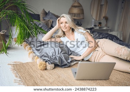 Happy beautiful blonde woman working, making video call, watching movie on a laptop in cozy home bedroom modern interior. Home quarantine Covid-19 pandemic Corona virus. Remote work from home concept. Royalty-Free Stock Photo #2438874223
