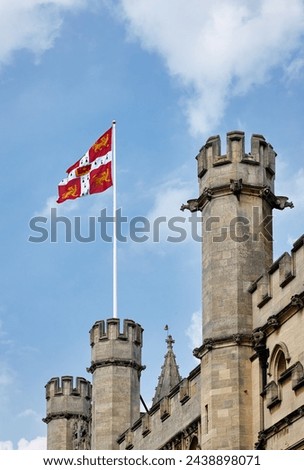 Flag of the University of Cambridge waving over battlemented walls and towers of Old Schools building. University of Cambridge. United Kingdom. Royalty-Free Stock Photo #2438898071