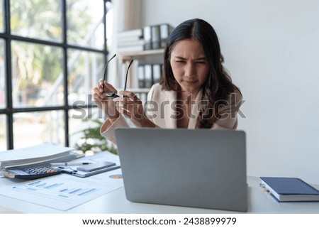 Asian businesswomen feel stressed at work when faced with hard work. Feeling headaches and eyestrain working on a laptop computer in the office.