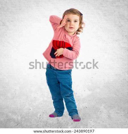 Little girl holding a Christmas hat over textured background 