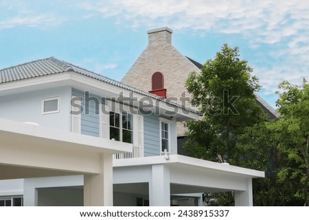 Beautiful architectural image of peaceful small home in countryside suburb of Bangkok, Thailand with green trees and freshness summer morning blue sky background.
