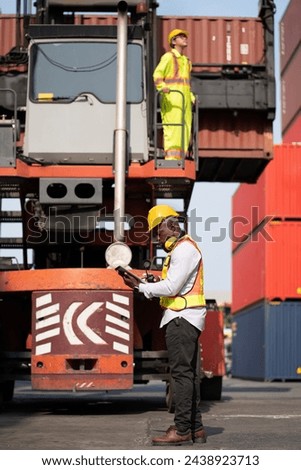 African logistic engineer man worker or foreman working direct driver forklift container with Asia worker at container site	