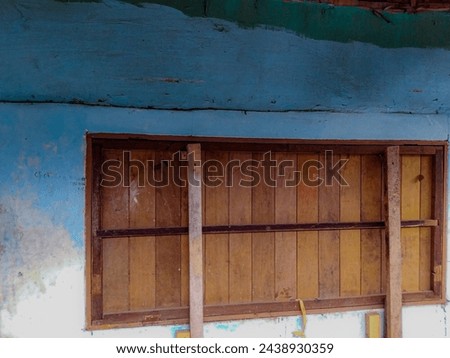 close up view of covered wooden window against worn blue walls