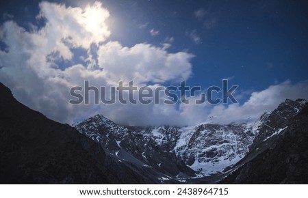 
Night landscape of a mountain range with rocks, snow and glaciers in the Fan Mountains in Tajikistan, Tien Shan highlands on a starry moonlit night
