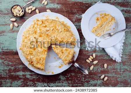 Traditional Swedish almond cake with almond flakes served as top view on a classic design plate  Royalty-Free Stock Photo #2438972385