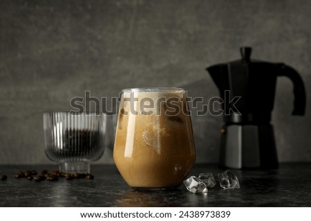 Glass with iced coffee drink, coffee maker and coffee bean on gray background Royalty-Free Stock Photo #2438973839