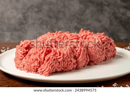 Ground beef. Butcher products. Fresh minced meat on dark background. Close up
