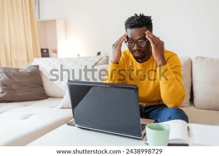 Cropped shot of a handsome young businessman sitting alone in his office and suffering from a headache. Worried man working with headache at home. Royalty-Free Stock Photo #2438998729