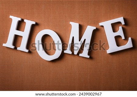 White letters with word HOME on cardboard surface