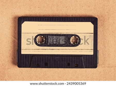 Toned Photo of Old Audio Tape Cassette on the Cardboard Background closeup