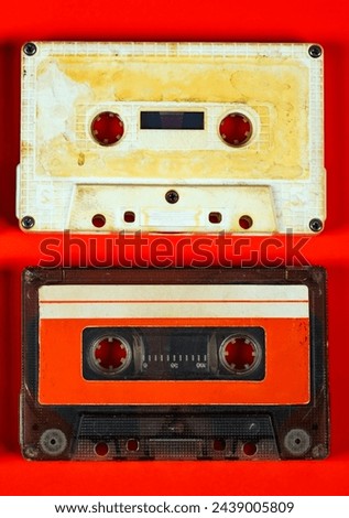 Pair of Old Audio Cassettes on Red Paper Background closeup