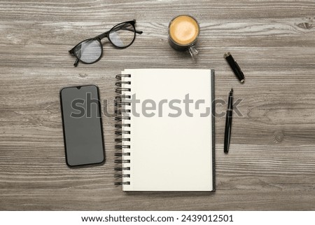 Flat lay composition with notebook and smartphone on wooden table