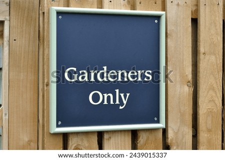 Close Up of Garden Sign on Wooden Fence 'Gardeners Only' 