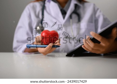 Doctor or cardiologist holding red heart shape in hand. Medical and health insurance concept