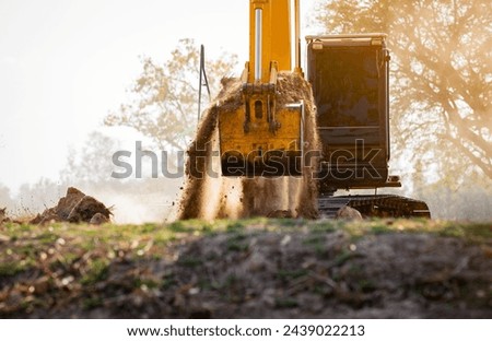 Backhoe working by digging soil at construction site.  Crawler excavator digging on demolition site. Excavating machine. Earth moving machine. Excavation vehicle. Construction business. Royalty-Free Stock Photo #2439022213