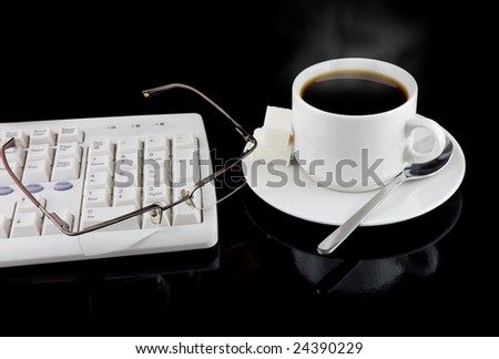 Cup of coffee, part of keyboard,glasses on a black background.