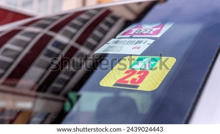 stickers on the front window allowing travel on toll roads in a SUV van Royalty-Free Stock Photo #2439024443