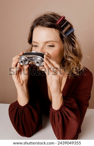 Woman looking through binoculars. Photo in studio with isolated 