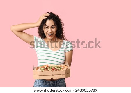 Beautiful young shocked African-American woman with delicious pizza on pink background