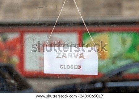 Old fashioned sign in the window of a shop saying in Hungarian "Zárva", meaning in English "Closed".