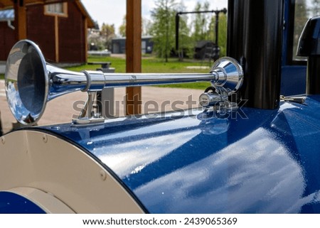 Close-up of the steel vintage signal horn on a blue car in the park, selective focus Royalty-Free Stock Photo #2439065369