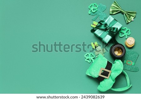 Leprechaun hat with gift box, pot of coins and decor on green background. St. Patrick's Day celebration