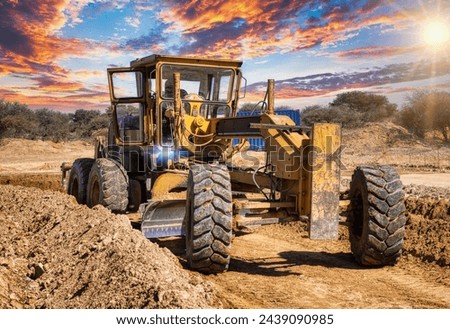 yellow grader digging the earth on a construction site at a diamond mine