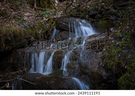 a waterfall in long exposure photography in the mountains