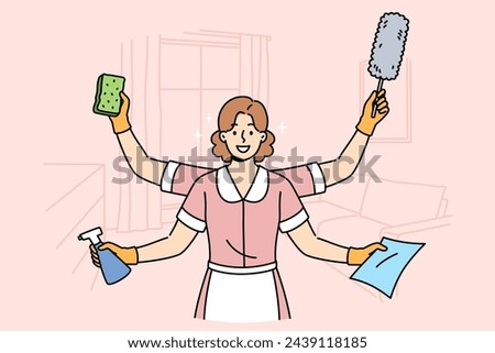 Woman maid is ready to quickly clean apartment, working in multitasking mode thanks to presence of four hands. Girl maid stands in hotel room and holds items to perform high-quality cleaning Royalty-Free Stock Photo #2439118185