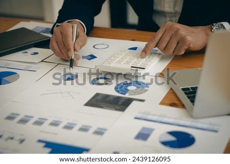 Young Asian male businessman is pressing a calculator to calculate income, taxes and expenses, credit card bill for payment or payday at home. Close-up pictures