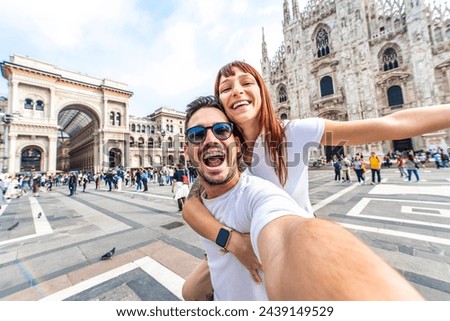 Happy couple taking selfie in front of Duomo cathedral in Milan, Lombardia - Two tourists having fun on romantic summer vacation in Italy - Holidays and traveling lifestyle concept