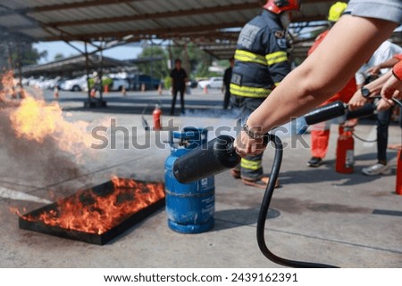 Employees firefighting training, Concept Employees hand using fire extinguisher fighting fire closeup. Spray fire extinguisher.
