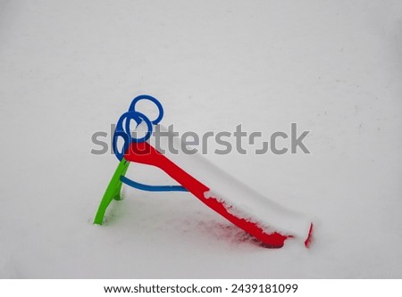 children's slide covered in snow