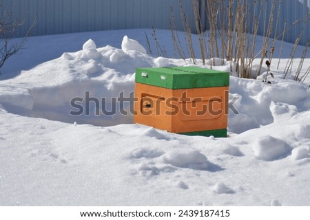 a lonely bee hive in the middle of a snow-covered field