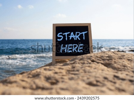 Start Here symbol. Concept word Start Here on black chalk background. Beautiful sea background. Business and Start Here concept. Copy space
