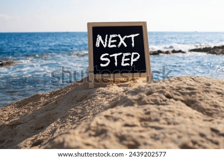 Next Step symbol. Concept words Next Step on black chalk background. Beautiful sea background. Business and Next Step concept. Copy space.