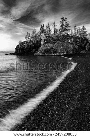 Tree covered rocks on a headland are seen from Black Beach, Silver Bay, Cook County, Minnesota Royalty-Free Stock Photo #2439208053