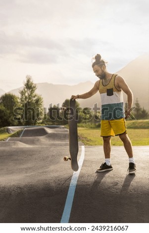 man skating in skatepark at sunrise with longboard cap and short hair