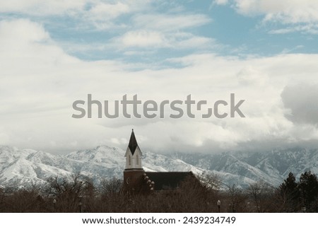 Historic church stands against the snowy Rocky Mountains in Salt Lake City.