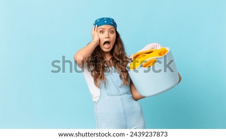 young pretty woman screaming with hands up in the air and holding a wash clothes basket