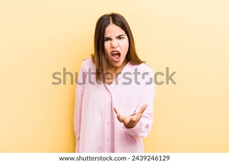 pretty hispanic woman looking angry, annoyed and frustrated screaming wtf or what’s wrong with you