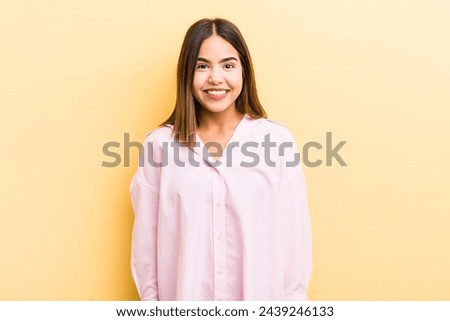 pretty hispanic woman looking happy and goofy with a broad, fun, loony smile and eyes wide open